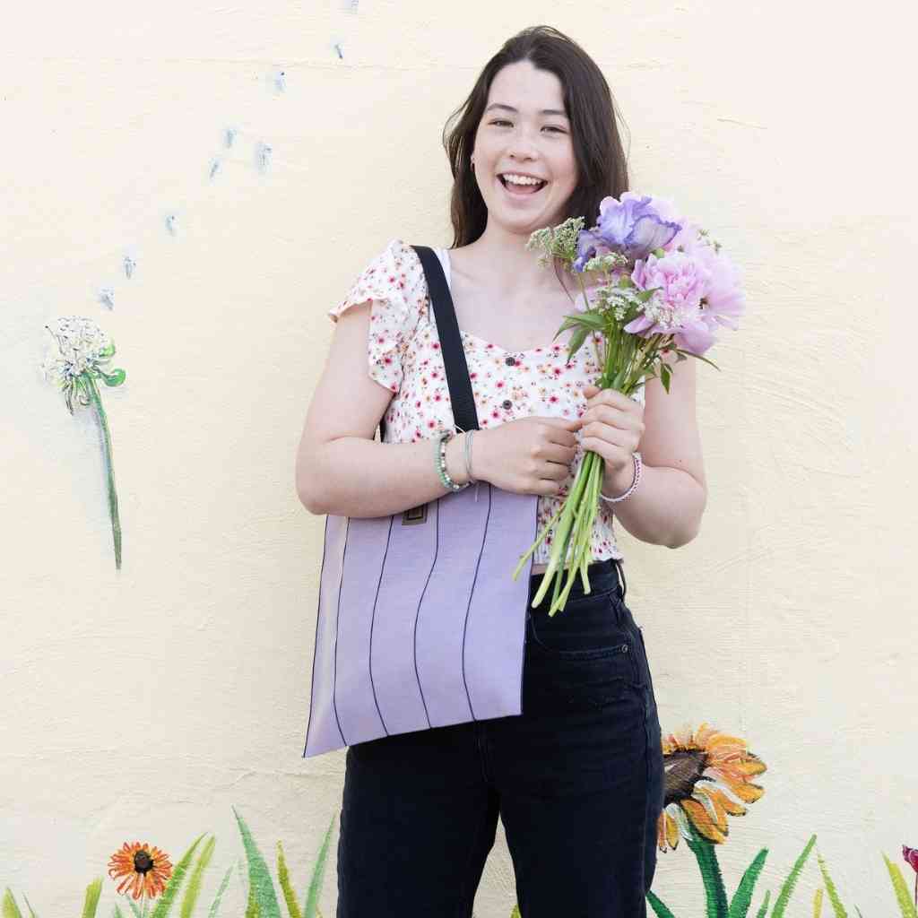 Luxury Simple Tote Bag Lavender Tote for work, school and play Non-canvas tote bag durable stain resistant tote bag stylish tote bag for college students Beautiful smiling young woman holding a bouquet of flowers with a light purple tote bag